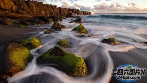 岩石海滩的 Arafed 景观，绿色岩石和海浪