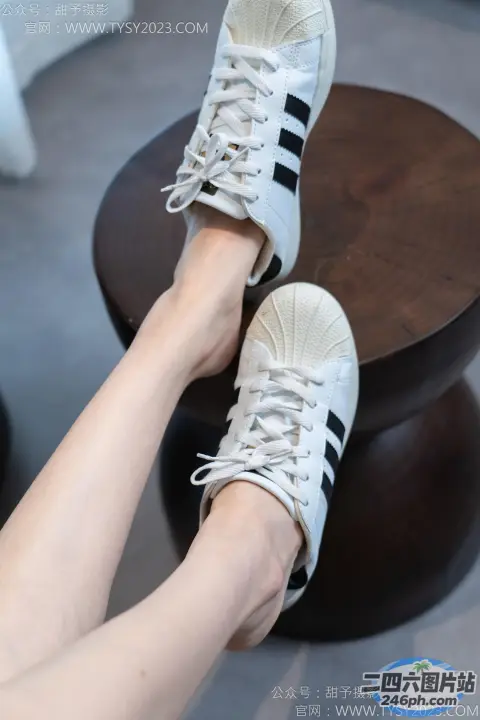 有人坐在凳子上，双脚抬起，双脚放在桌子上